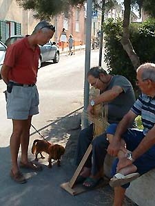 Ty and Rudy watch a local Sardinian man weave a fish trap